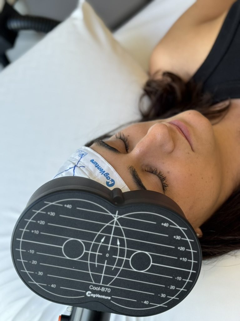 A woman resting with her eyes closed during an rTMS session